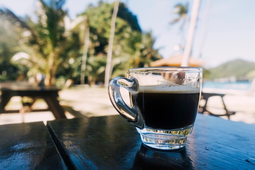 Espresso cup on a beachside table in Thailand